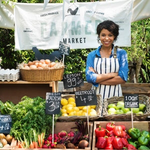 female vendor standing at a farmers market