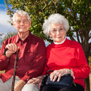 senior couple sitting on park bench